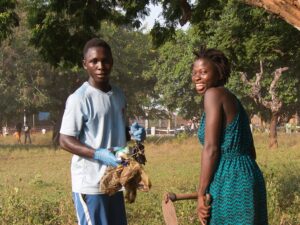 A young couple participating in the cleaning action in Bolama.